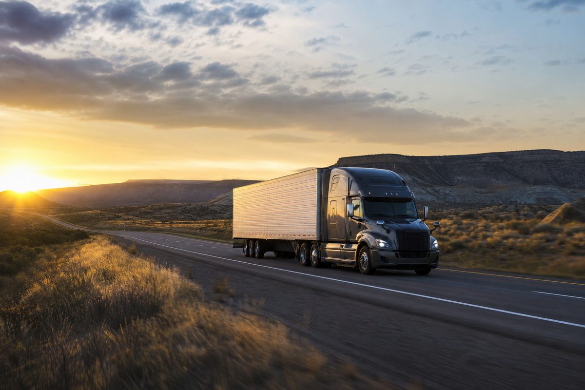 Semi-truck on an open American highway at golden hour